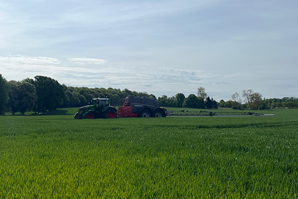 Traktor der kører med sprøjte i hvedemark